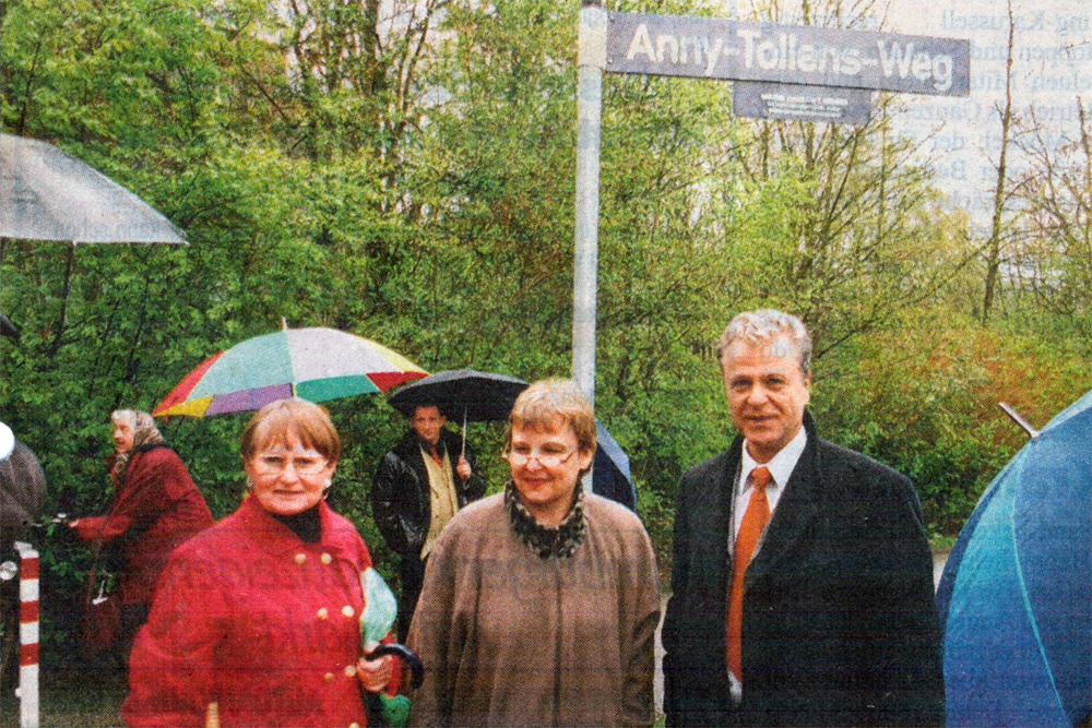 Drei personen unter dem Straßenschild Anny-Tollens-Weg