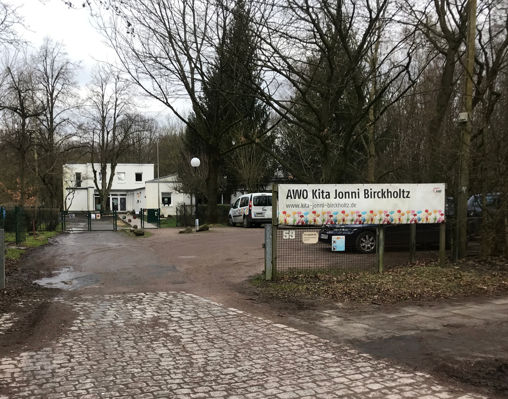 Einfahrt auf ein Gelände. rechts Schild mit der Aufschrift 