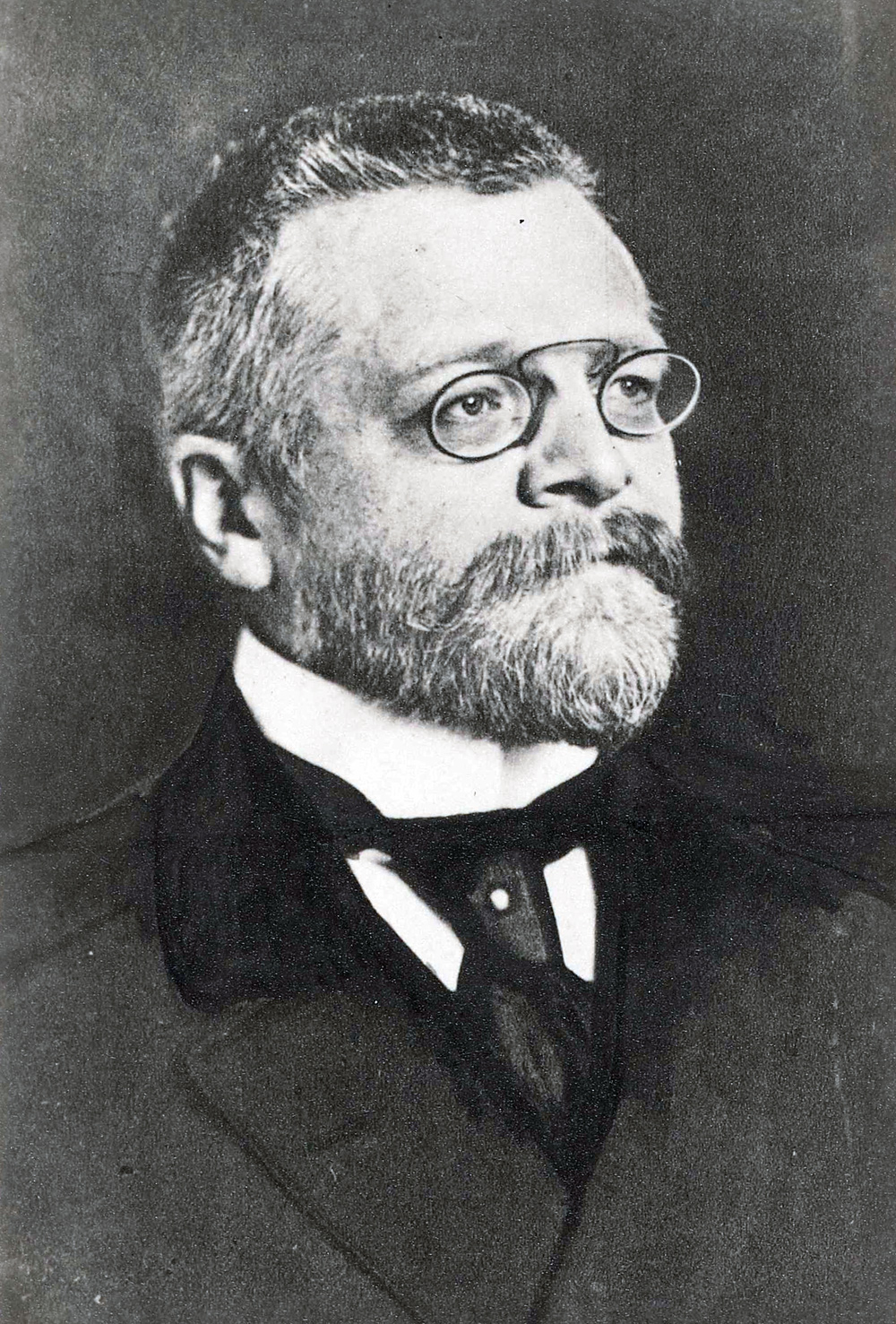 Portraitfoto eines Mannes mit Nasen-Klemm-Brille und Vollbart