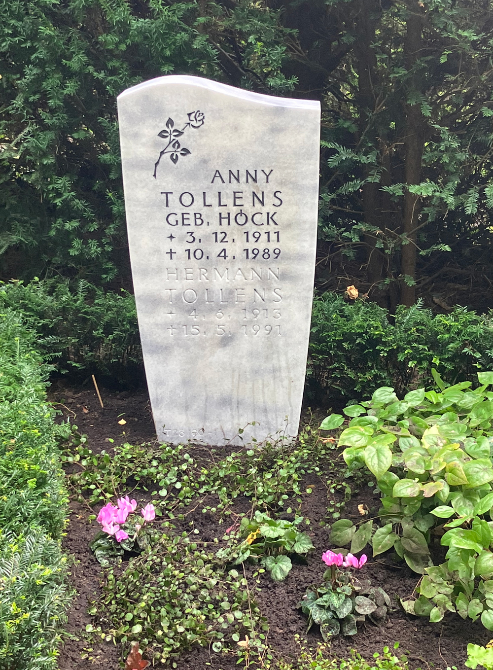 Weißer Grabstein mit eingravierter Blume