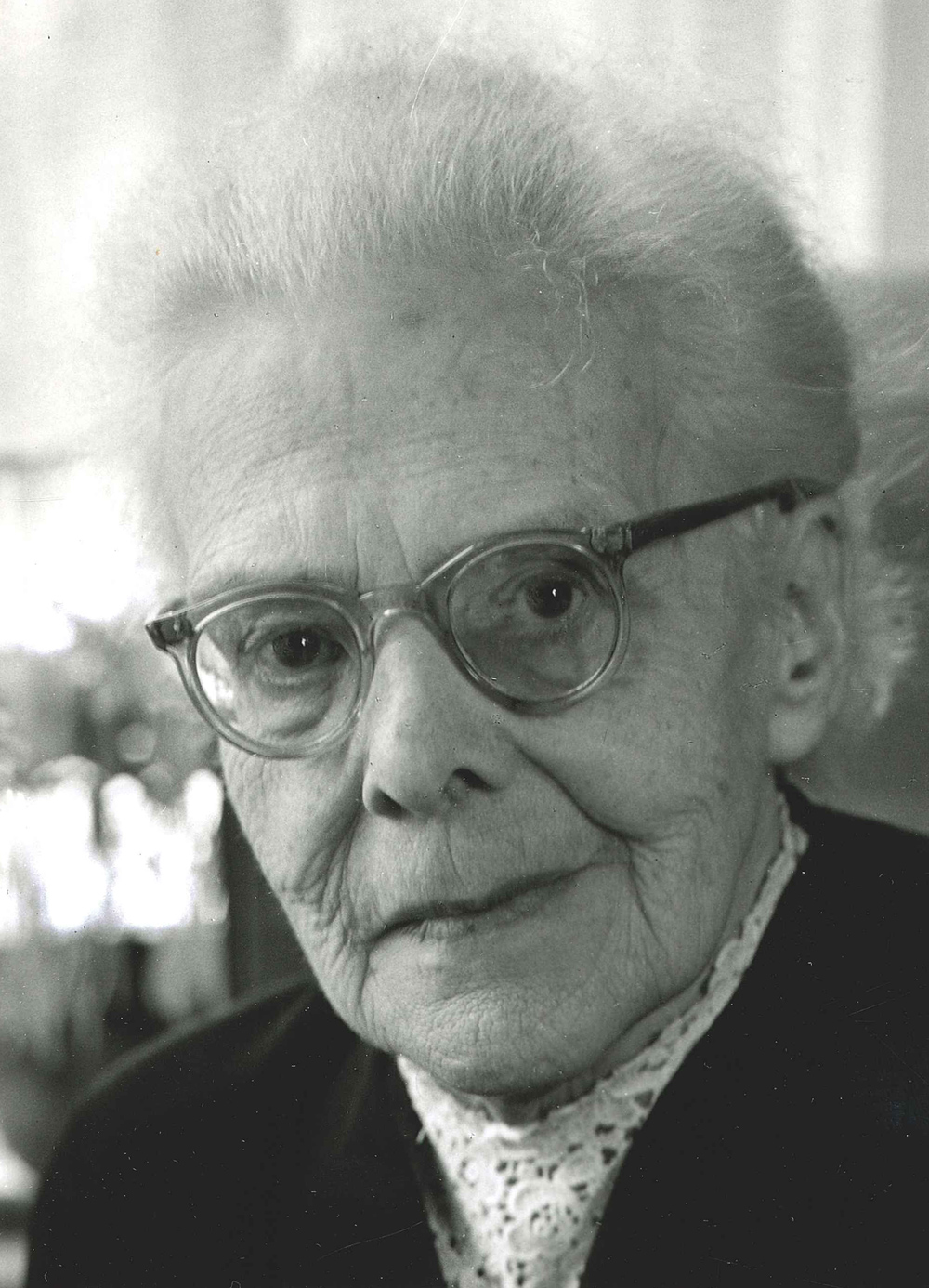 Portrait einer alten Frau mit weißen Haaren und Brille