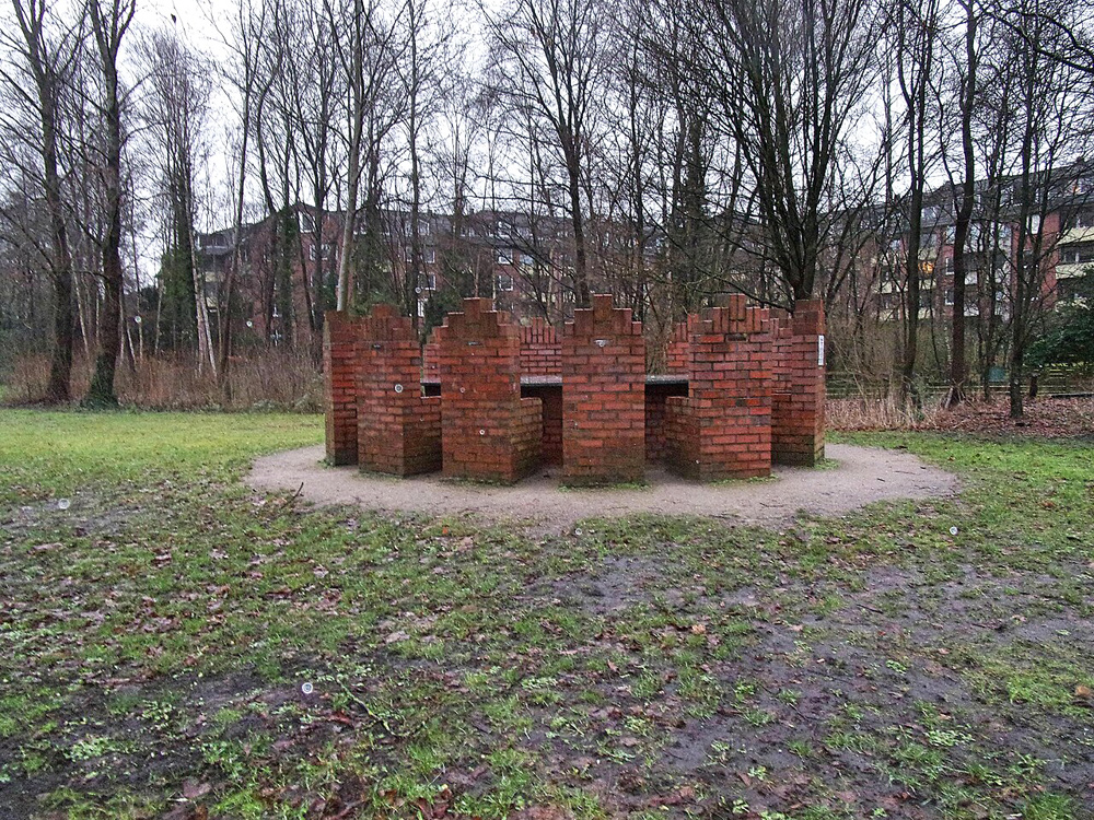 Mahnmal aus 12 gemauerten Stühlen um einen Tisch