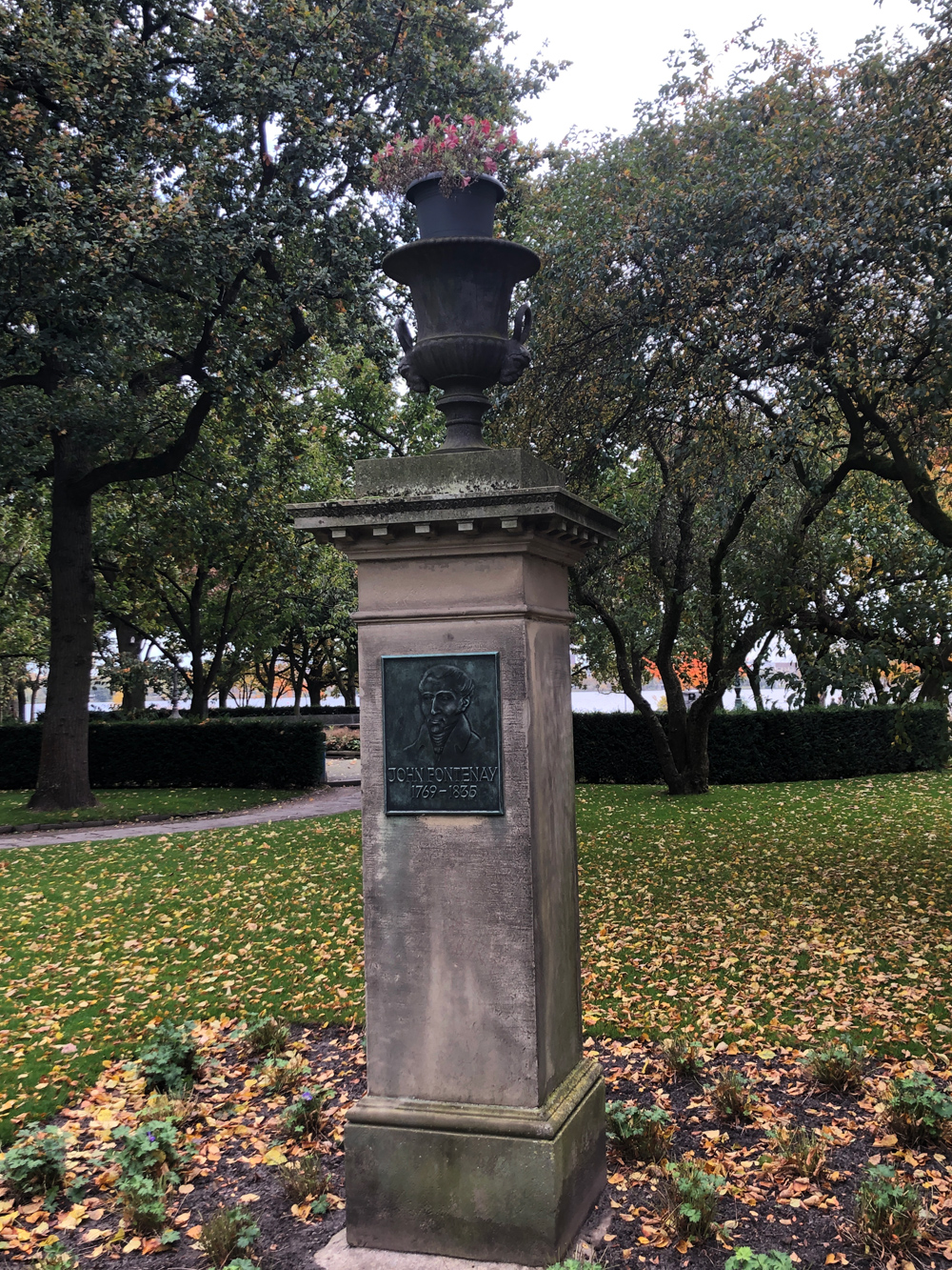 einer Stele aus Sandstein, an der ein Relief aus Bronze mit einem Porträt angebracht ist
