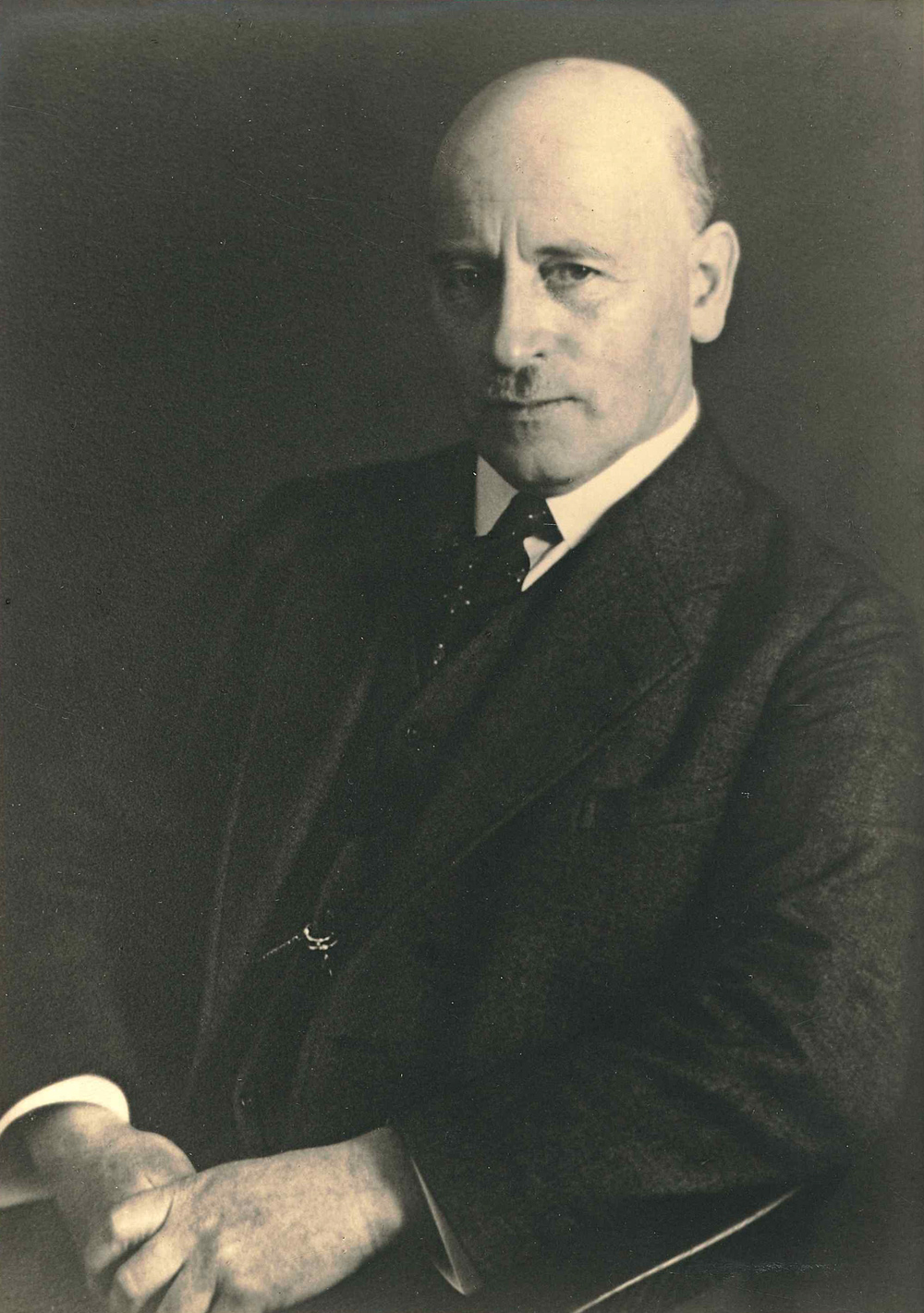 Portraitfoto eines Mannes im Anzug, sitzend